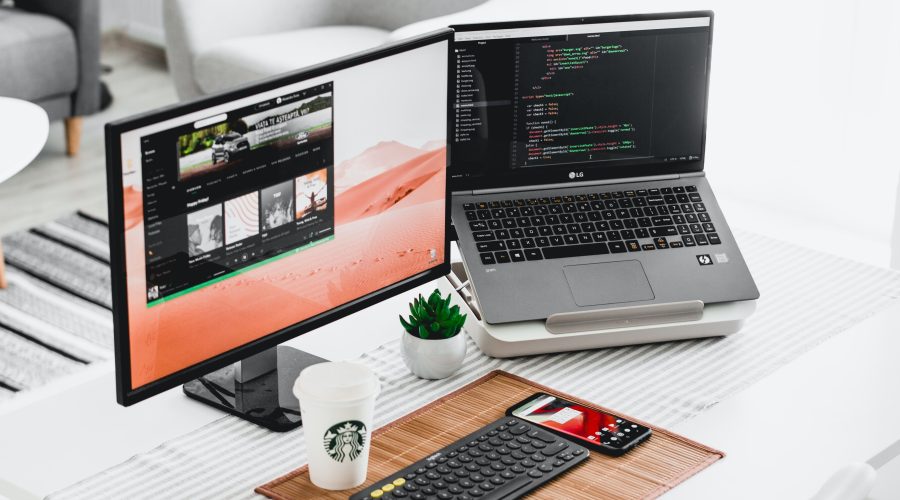 A computer table is displayed with 2 open laptops