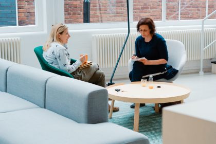 Two woman are sitting and talking