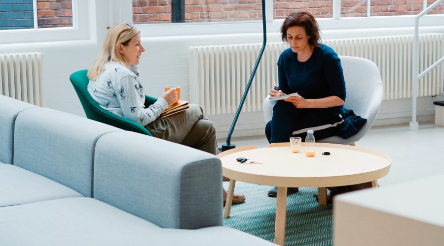 Two woman are sitting and talking