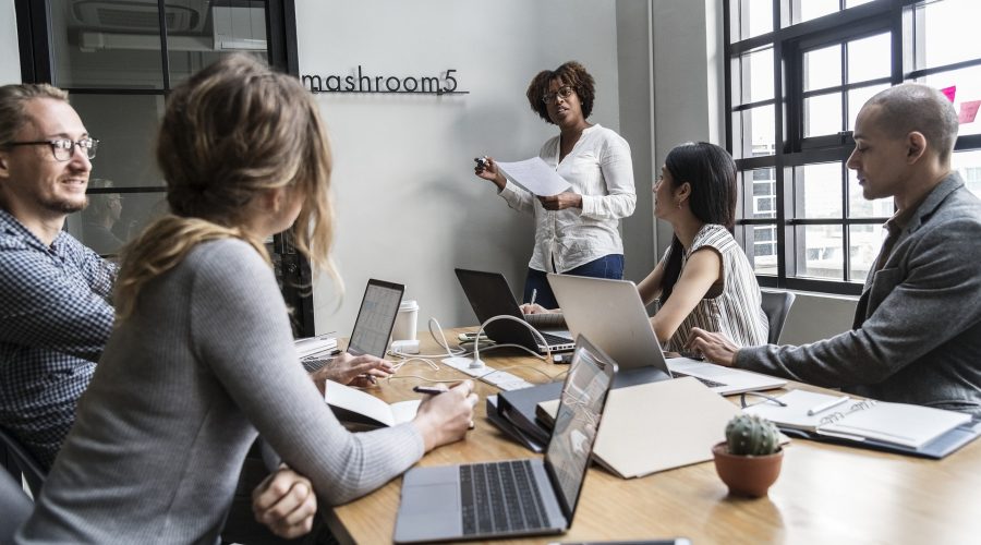 Coaching Competencies 3 and 4 Speak to Diversity A group of women are in a conference room talking.