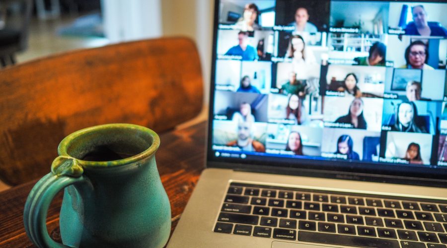 An open laptop with numerous pictures of people on the computer screen.