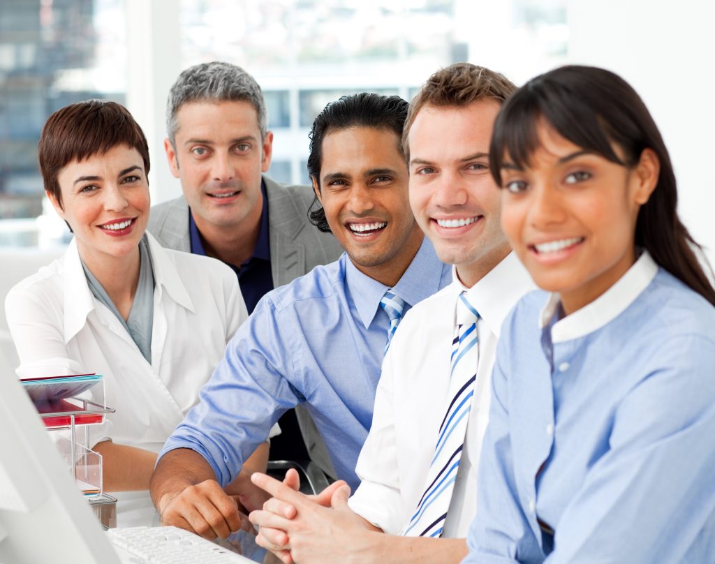 A group of men and woman, all in business attire, are sitting in a semi-circle