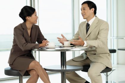 A woman and man are sitting at a table talking.