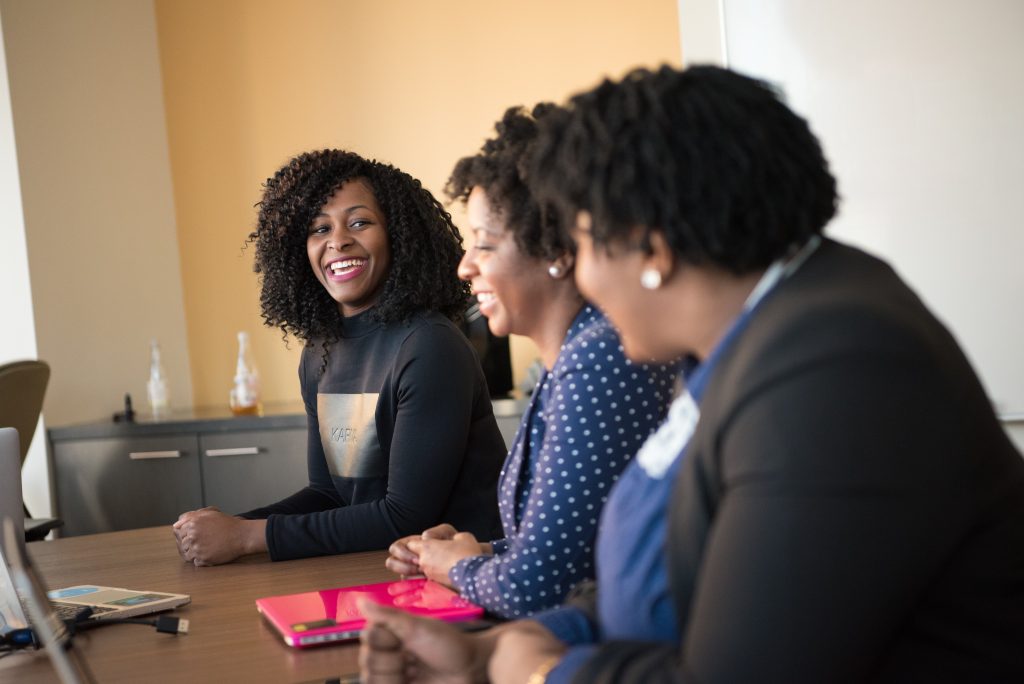 3 African American woman are sitting at table talking