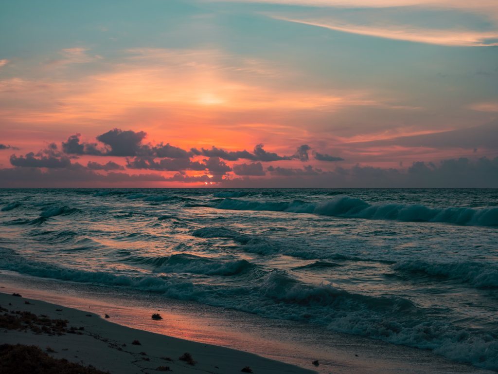 Picture of sunset, with waves on a cliff side beach