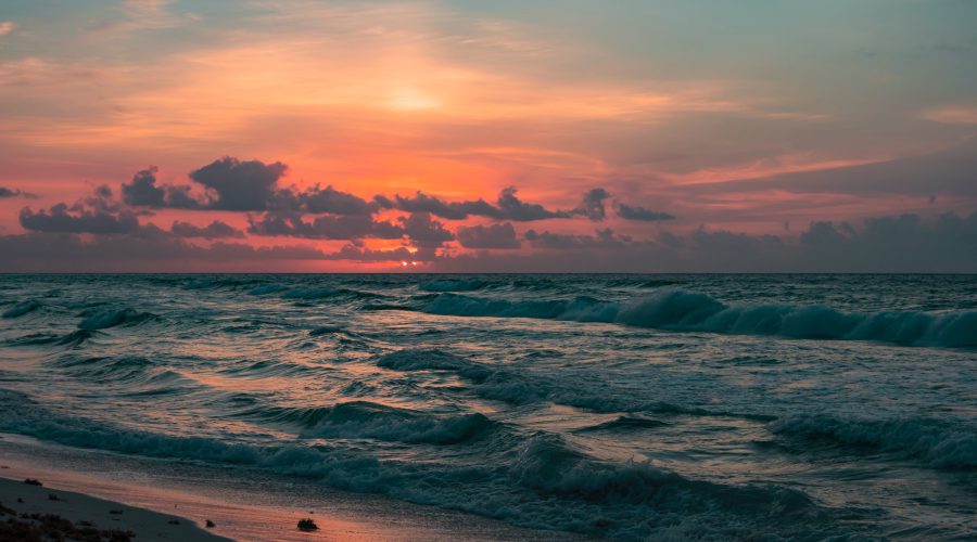 Picture of sunset, with waves on a cliff side beach