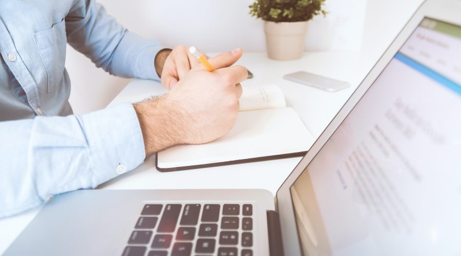 A man is sitting at a desk with a laptop