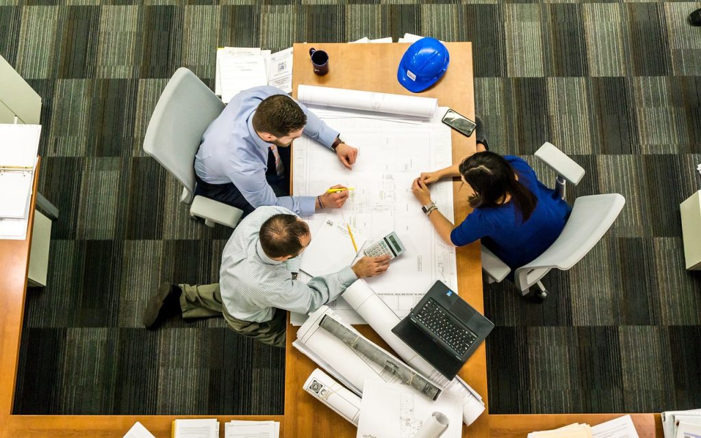 A group of people are sitting at a desk talking 