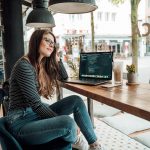 A woman is sitting at a desk pondering a htought