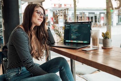 A woman is sitting at a desk pondering a htought