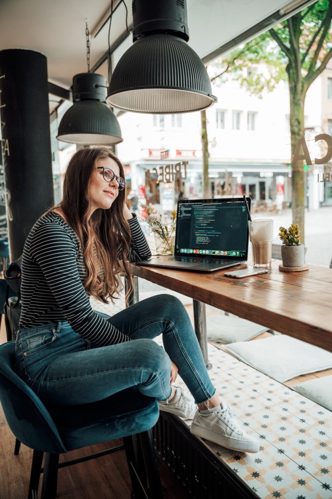 A woman is sitting at a desk pondering a htought