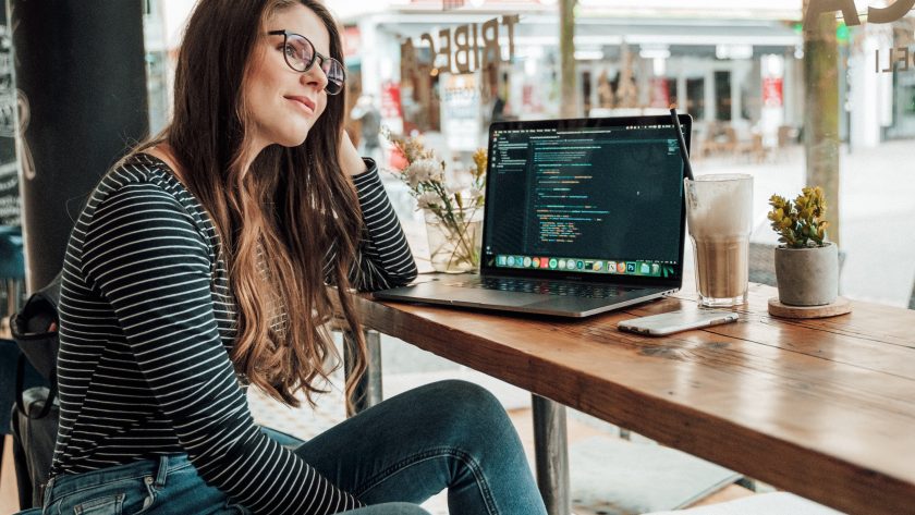 A woman is sitting at a desk pondering a htought