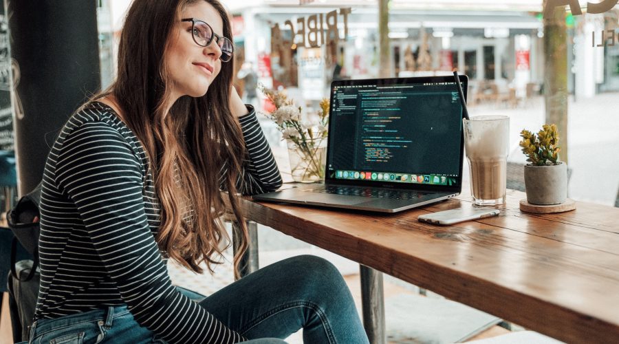 A woman is sitting at a desk pondering a htought