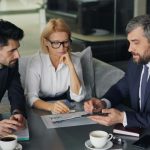 2 Men and a woman are sitting and talking about something
