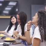 A group of ladies are sitting at tables talking