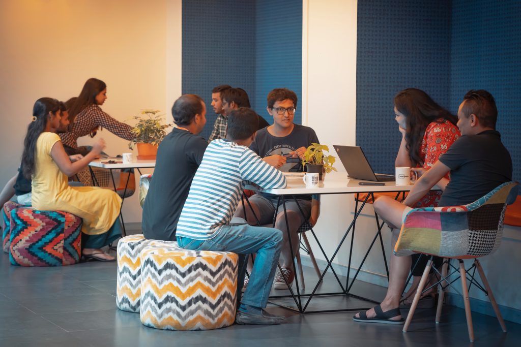 A group of men and woman are sitting and appear to be studying