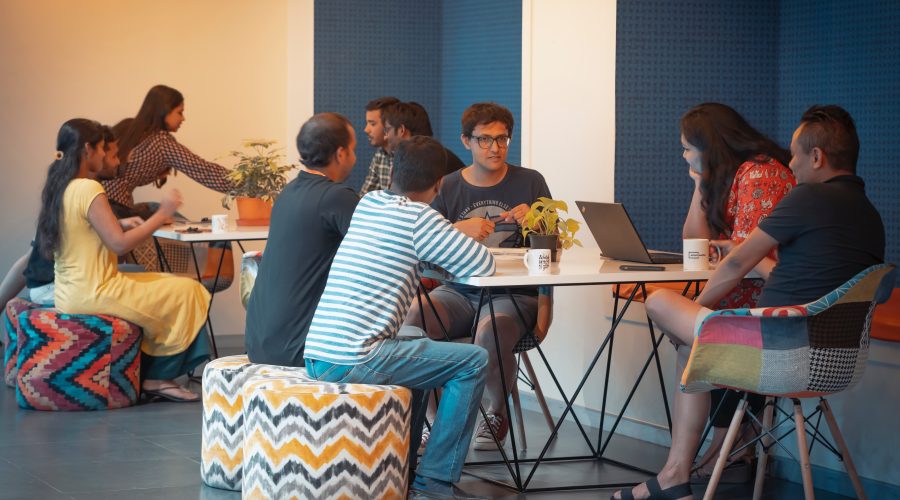 A group of men and woman are sitting and appear to be studying