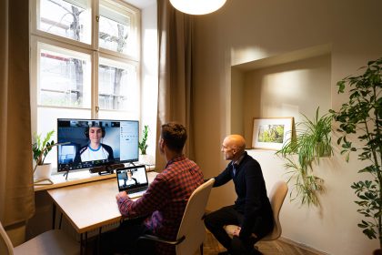 2 Men are sitting at a computer on a video call