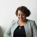 Steps to Earn Your Coaching Certification and Start Coaching Clients An African American woman is sitting and reading or studying