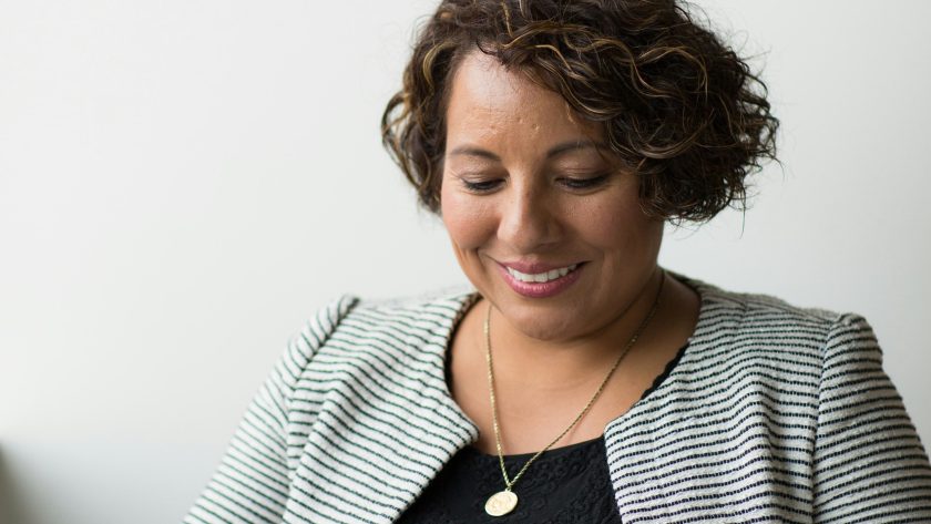 Steps to Earn Your Coaching Certification and Start Coaching Clients An African American woman is sitting and reading or studying