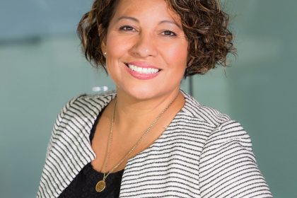 A business woman is standing and looking g at the camera