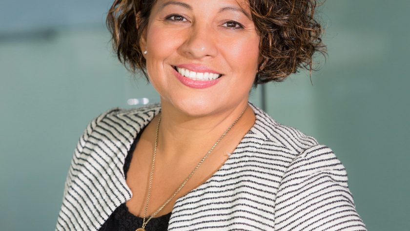 How To Use Coaching Skills in Everyday Leadership A business woman is standing and looking g at the camera