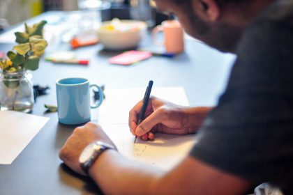 A man is sitting and writing