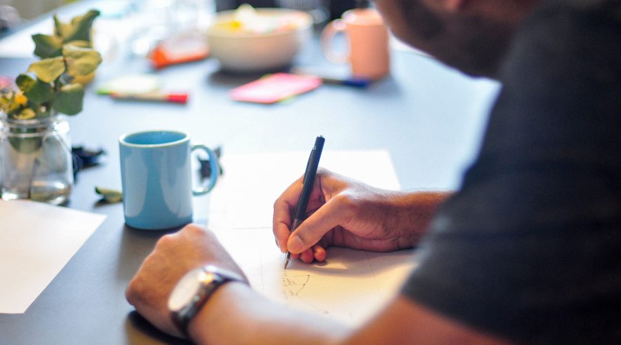 A man is sitting and writing
