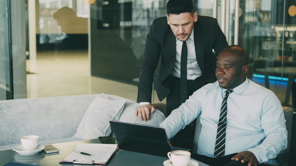 2 Business men are talking in an office.