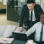 2 Business men are talking in an office.