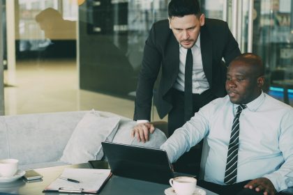 2 Business men are talking in an office.