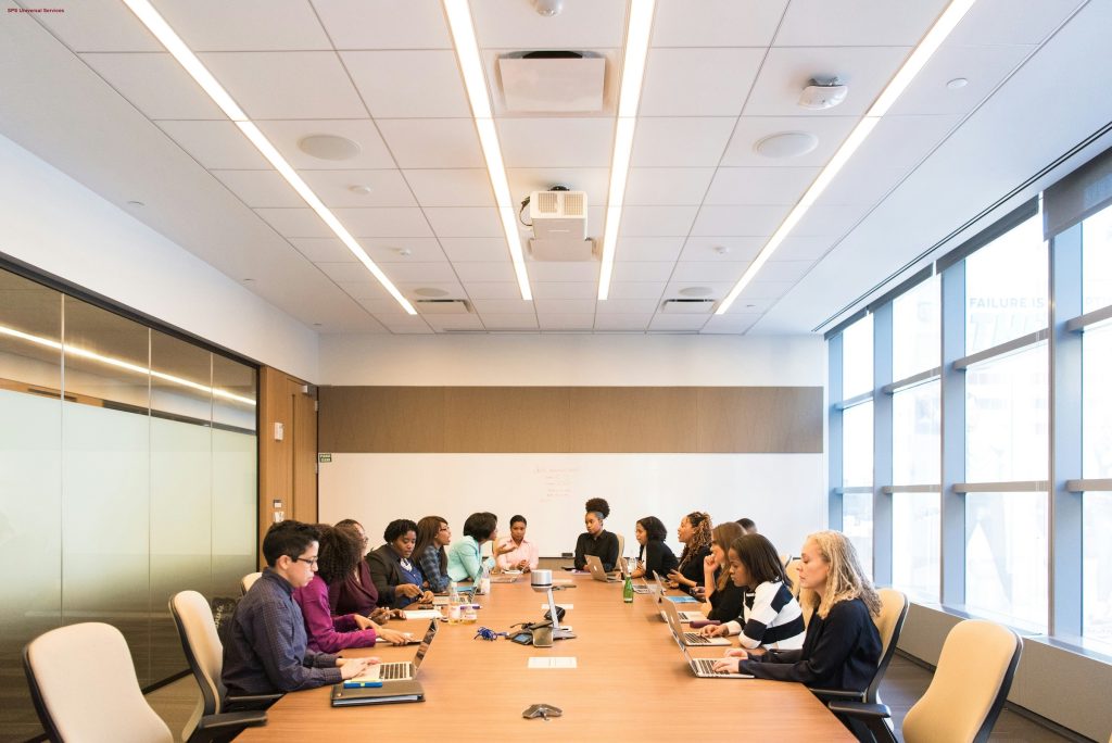 A large group of people are sitting round a large conference center 