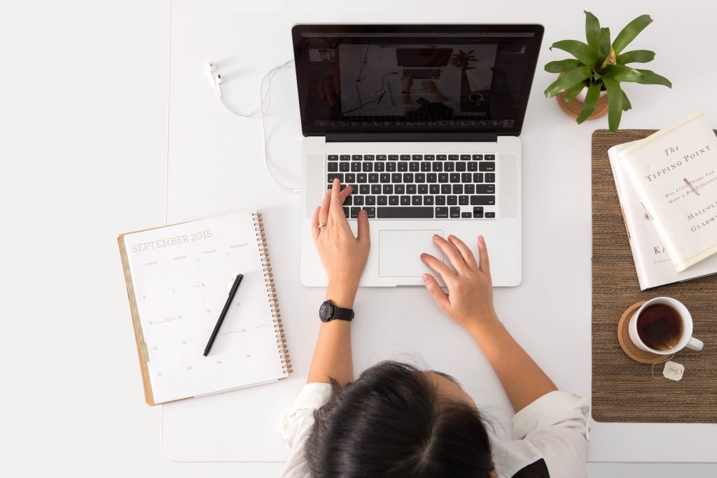 A woman is sitting at her desk working on her computer