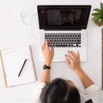 A woman is sitting at her desk working on her computer