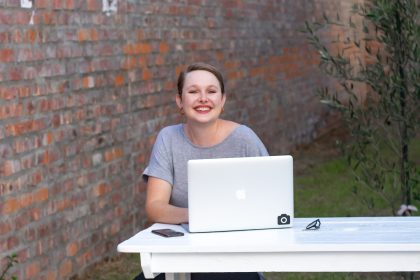 Coaching Certification - An Investment In You A woman is sitting outside with her laptop computer