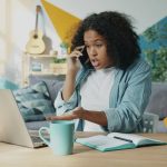 A African American woman is sitting and looks upset or frustrated