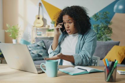 A African American woman is sitting and looks upset or frustrated