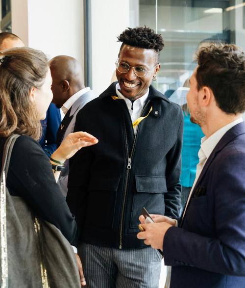 Diverse group of people socialize and converse in a well lit space